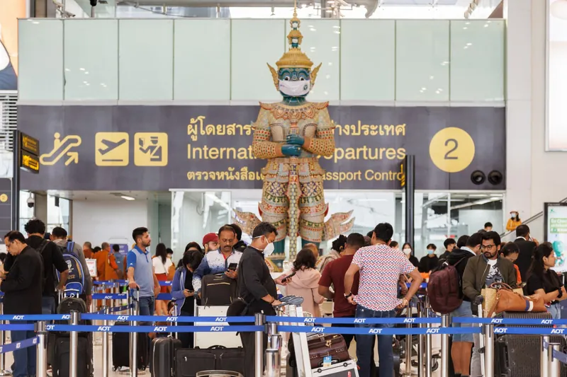 Travellers queuing at international departures and passport control in Bangkok's Suvarnabhumi airport