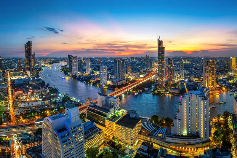 Bangkok's skyline and the Chao Phraya river lit up at twilight