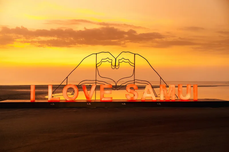 Glowing I LOVE SAMUI sign on a Koh Samui beach at sunset