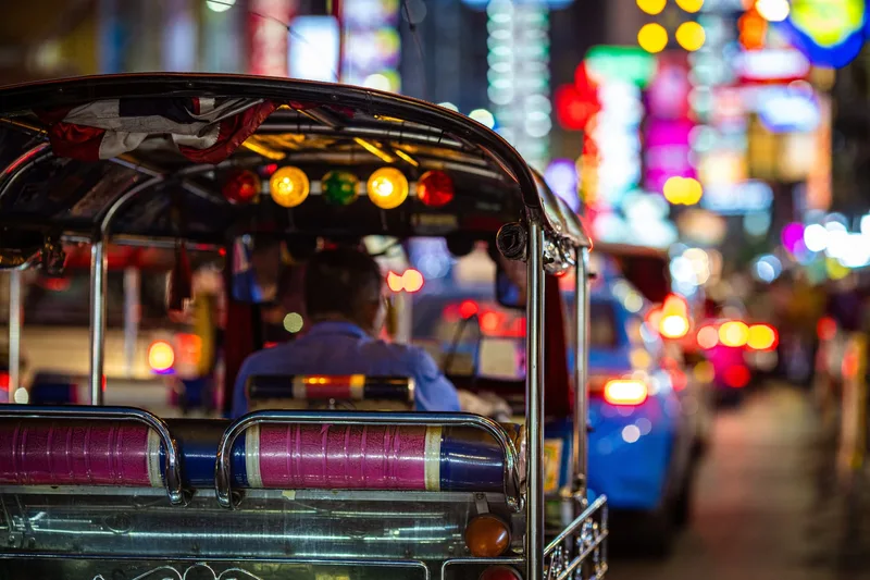 The view from a tuk-tuk in Bangkok traffic under Chinatown's neon lights